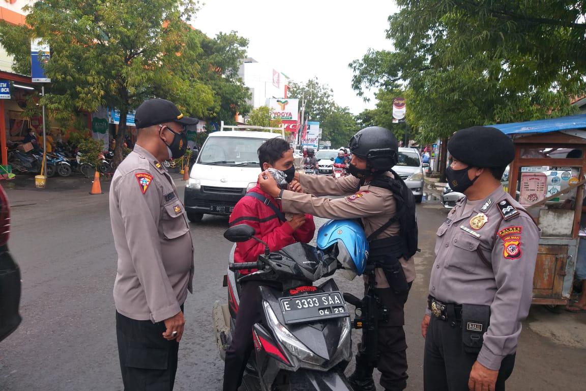 Personil Brimob Jabar Bagikan Masker Kepada Masyarakat Saat Ops Yustisi Gabungan di Cirebon