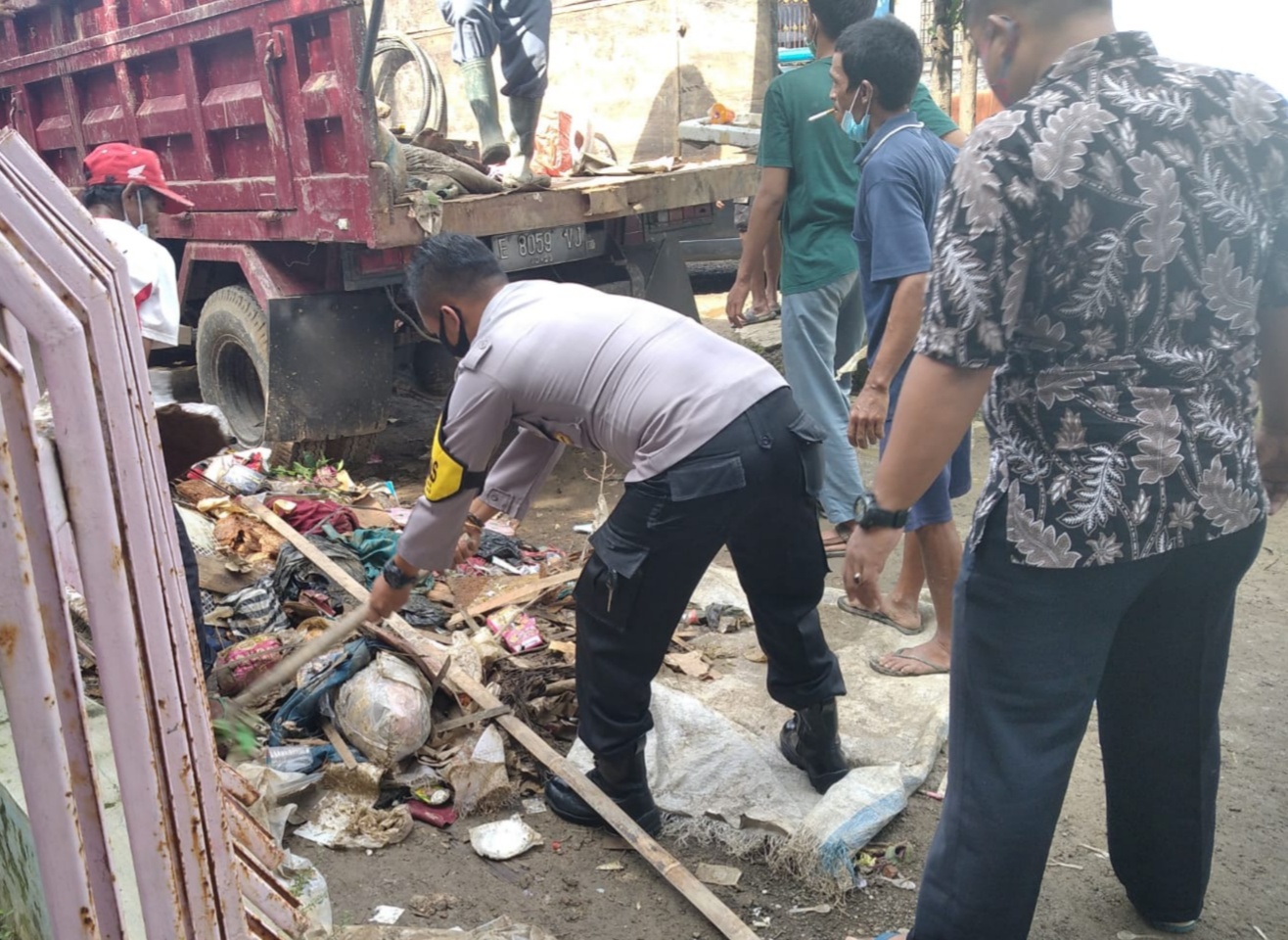 Aksi Peduli Bhabinkamtibmas Polsek Dawuan Bantu Warga Bersihkan Sampah dan Lumpur Sisa Banjir