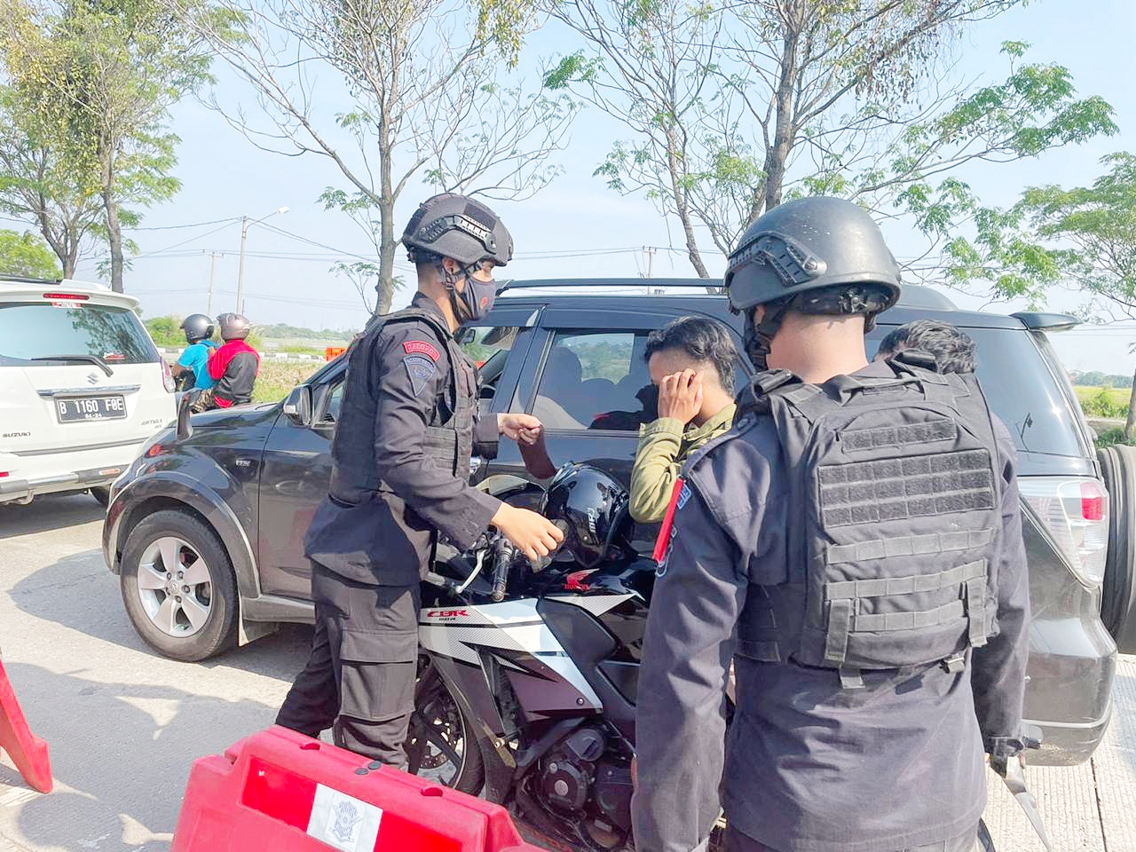 Brimob Jabar Bagikan Masker Kepada Warga Yang Melewati Pos Pam Kepuh Karawang