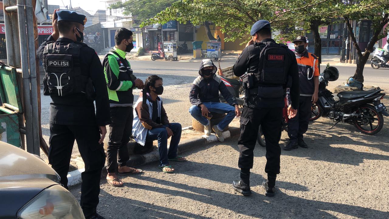 Sambangi Ojol, Personel Brimob Jabar Ingatkan Prokes Ditengah PPKM