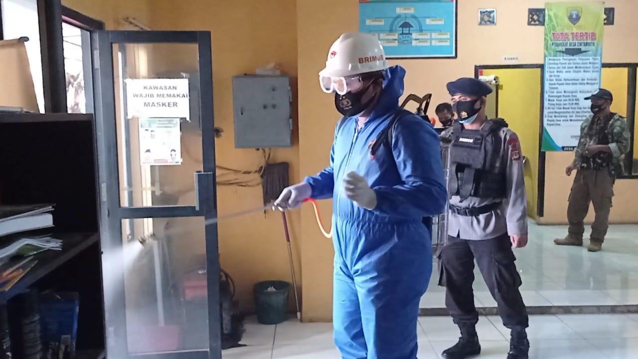 Brimob Jabar Semprotkan Disinfektan Ke Kantor Desa Cintamulya